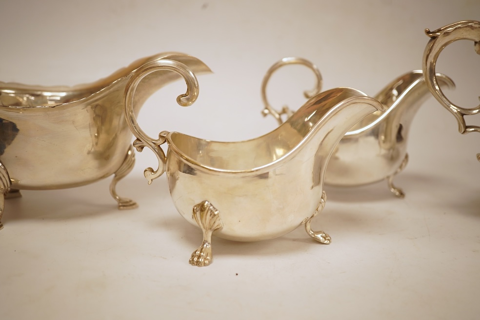 A pair of George V silver sauceboats, with cut borders and flying scroll handles, on three hoof feet, by J.B. Chatterley & Co Ltd, Birmingham, 1928, length 19.3cm, 19.3oz, together with a pair of silver plated Elkington